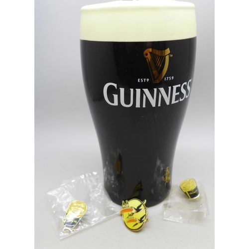 2290 - A Guinness novelty money box and three badges