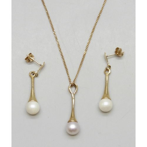 7162 - A 9ct gold chain with a yellow metal cultured pearl drop pendant, 2.2cm, and a pair of matching yell... 