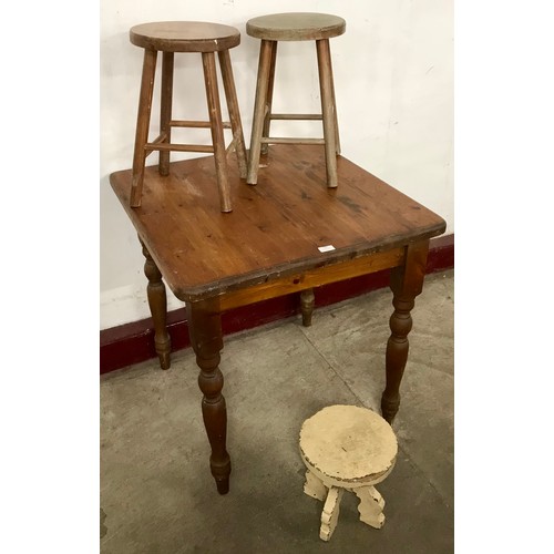 192 - A pine table and three pine stools