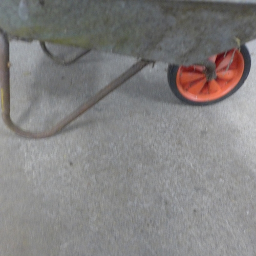5244 - A metal wheelbarrow with drain rods and saw