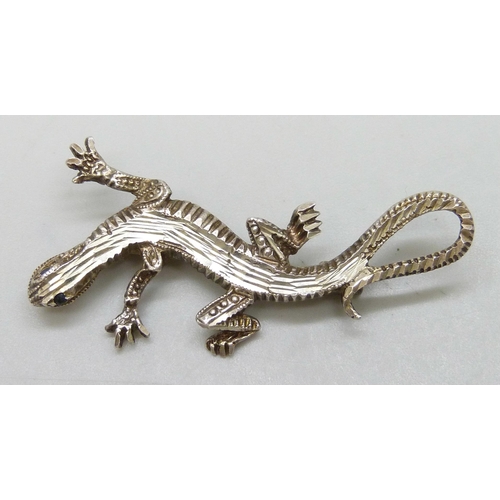 7093 - A silver animal brooch in the form of a lizard, set with sapphire eyes, 4.5cm