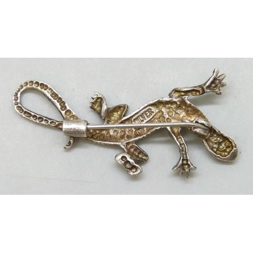 7093 - A silver animal brooch in the form of a lizard, set with sapphire eyes, 4.5cm