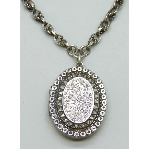 7133 - A Victorian silver locket, on a silver rope design Albert chain with two dog clips, each link marked... 