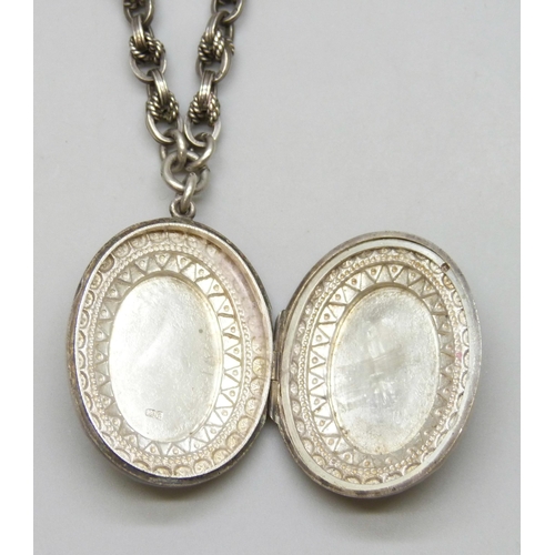 7133 - A Victorian silver locket, on a silver rope design Albert chain with two dog clips, each link marked... 