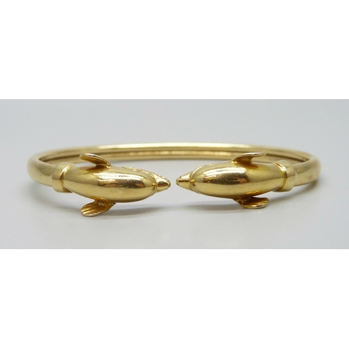 7001 - An 18ct gold dolphin design bangle, marked 750, 14.7g, 6.1 x 4.5cm