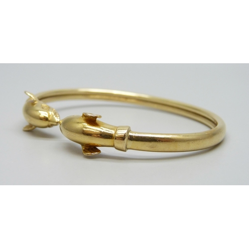 7001 - An 18ct gold dolphin design bangle, marked 750, 14.7g, 6.1 x 4.5cm