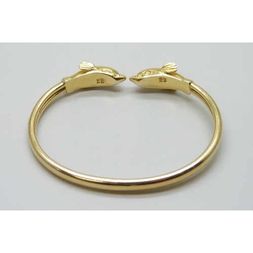 7001 - An 18ct gold dolphin design bangle, marked 750, 14.7g, 6.1 x 4.5cm