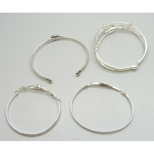 7058 - Three silver bangles and one white metal bangle, 48g total