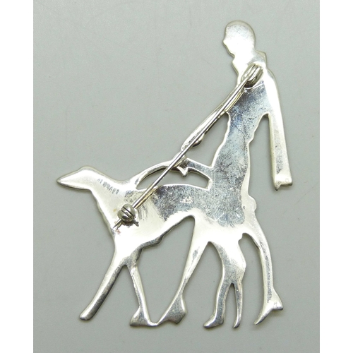 7082 - An Art Deco style silver brooch in the form of a lady walking a dog, 6.6cm