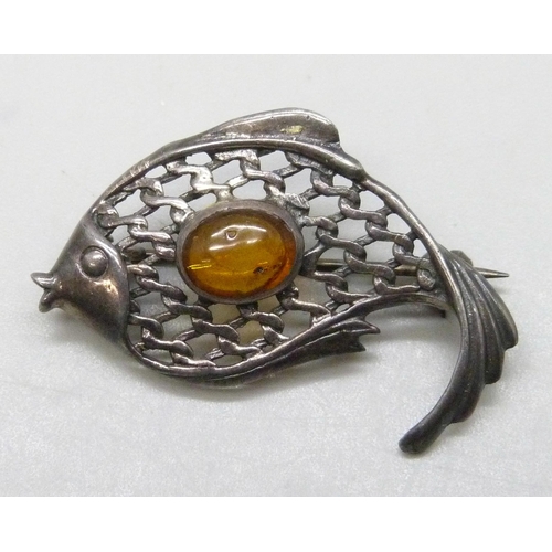 7147 - A silver brooch in the form of a fish, set with Baltic amber, 3.6cm