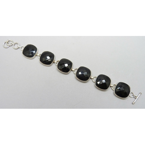 7169 - A chunky silver bracelet set with faceted onyx stone panels, 43g, 21cm full extension, stones 2cm