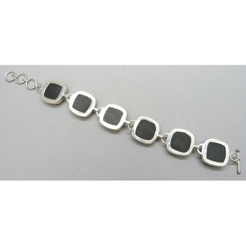 7169 - A chunky silver bracelet set with faceted onyx stone panels, 43g, 21cm full extension, stones 2cm