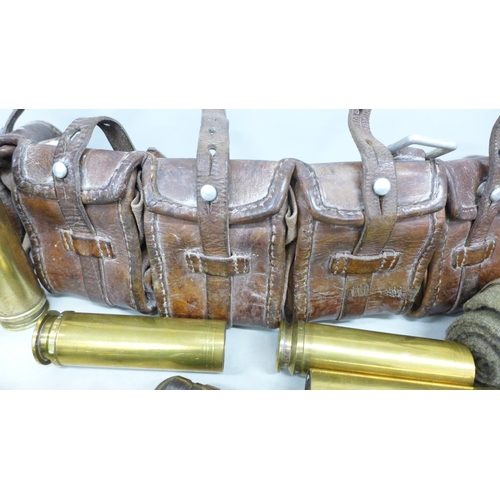 2057 - A collection of military shell cases, a leather ammunition belt, etc.