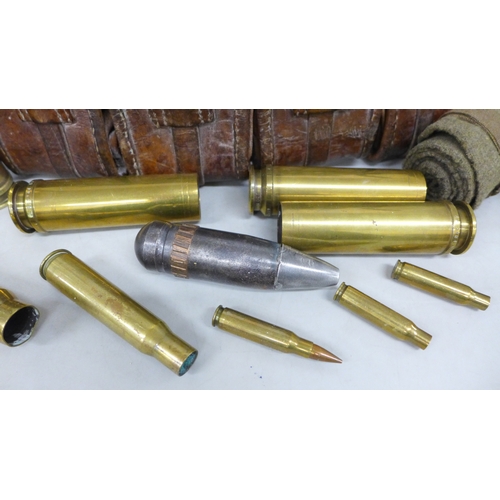 2057 - A collection of military shell cases, a leather ammunition belt, etc.