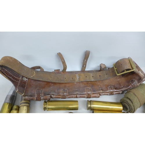 2057 - A collection of military shell cases, a leather ammunition belt, etc.
