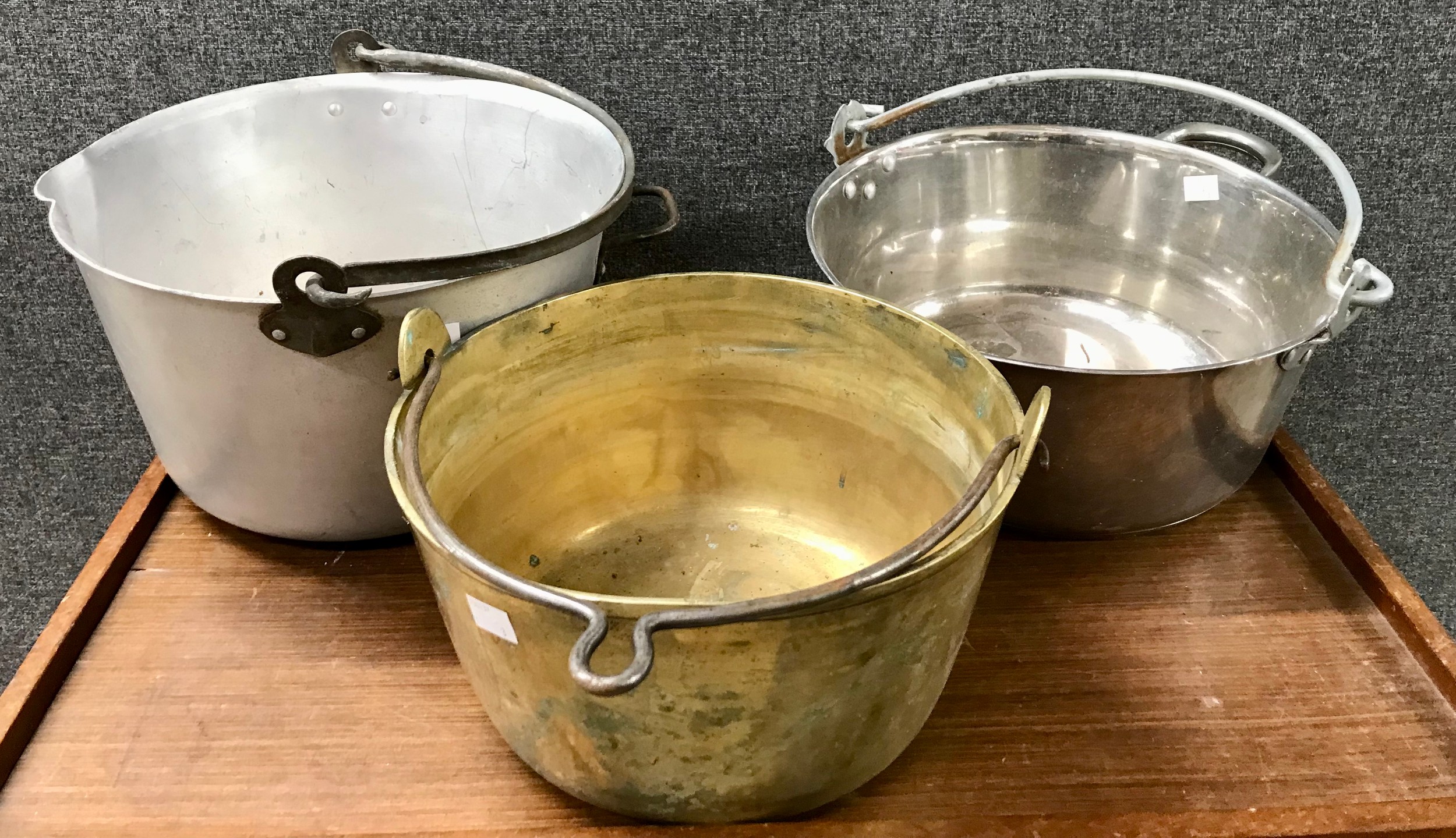 A brass jam pan and two others