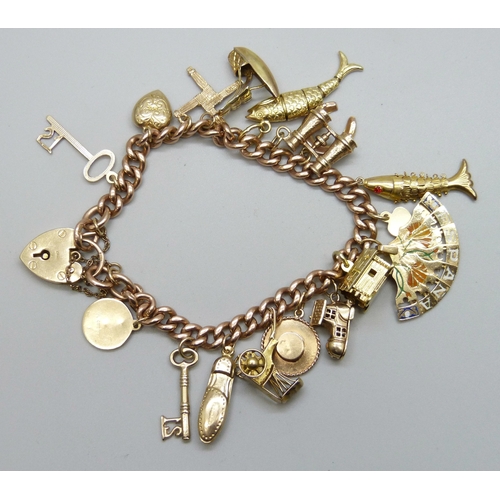7092 - A 9ct gold curb chain charm bracelet with a collection of charms - ten 9ct gold charms, an 18ct gold... 