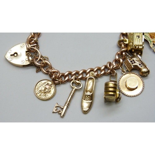7092 - A 9ct gold curb chain charm bracelet with a collection of charms - ten 9ct gold charms, an 18ct gold... 
