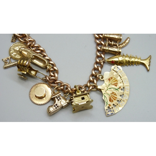 7092 - A 9ct gold curb chain charm bracelet with a collection of charms - ten 9ct gold charms, an 18ct gold... 