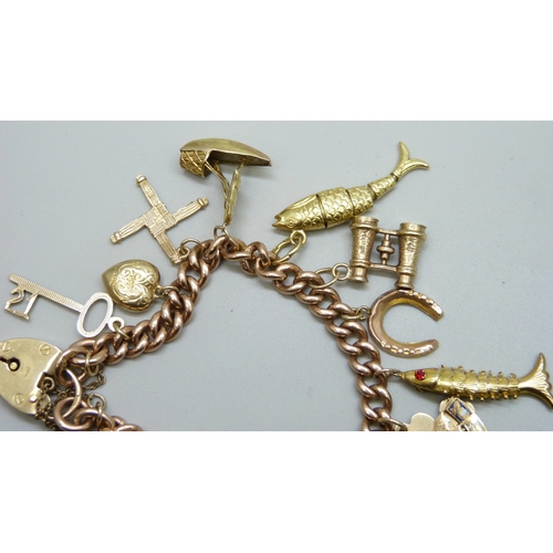 7092 - A 9ct gold curb chain charm bracelet with a collection of charms - ten 9ct gold charms, an 18ct gold... 