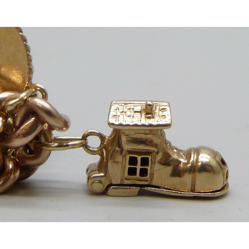 7092 - A 9ct gold curb chain charm bracelet with a collection of charms - ten 9ct gold charms, an 18ct gold... 