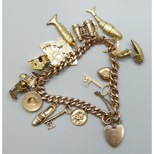 7092 - A 9ct gold curb chain charm bracelet with a collection of charms - ten 9ct gold charms, an 18ct gold... 