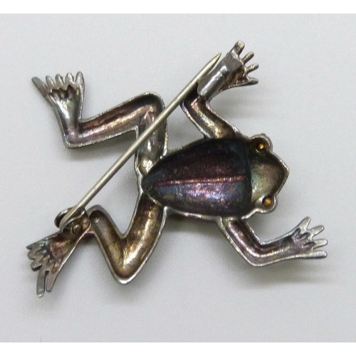 7096 - An Art Deco white metal brooch in the form of a frog set with green stone eyes, tests as silver, 3.7... 
