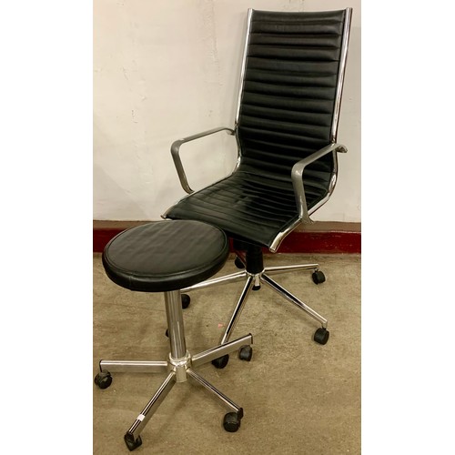 68C - An Eames style black leather and chrome revolving desk chair and footstool