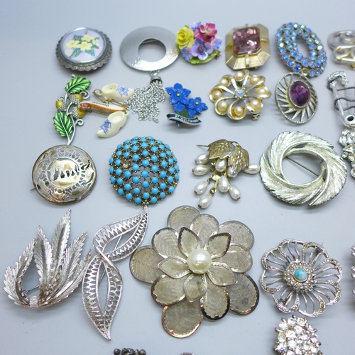 7170 - Thirty four brooches including a floral silver example (9g)