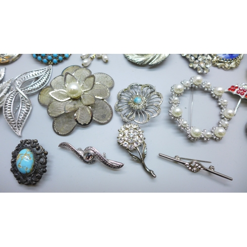 7170 - Thirty four brooches including a floral silver example (9g)