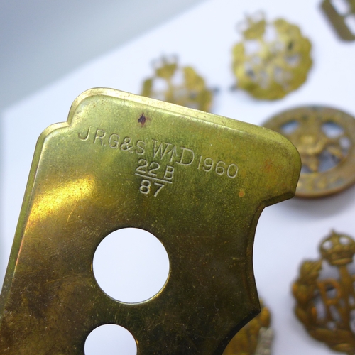 2170 - A collection of military cap badges, and a button polishing guard