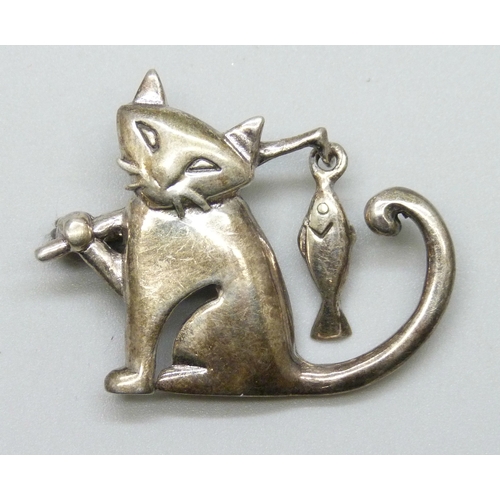 7066 - A silver brooch in the form of a cat carrying a fish, 3.2cm
