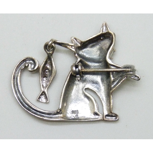 7066 - A silver brooch in the form of a cat carrying a fish, 3.2cm