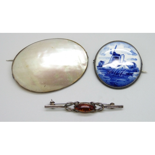 7067 - A large early 20th Century white metal and mother of pearl brooch, a white metal framed Dutch delft ... 