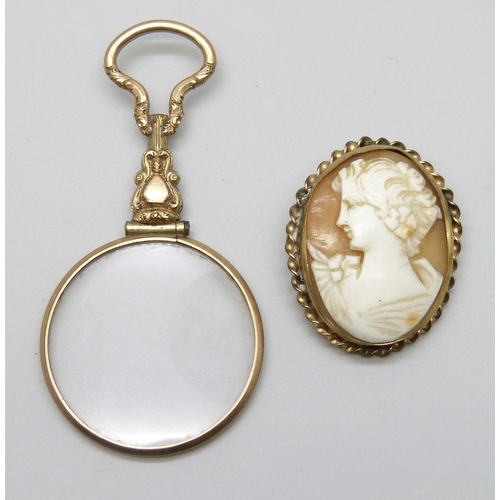 7071 - A gilt magnifying glass, 6.8cm, and a gilt cameo brooch