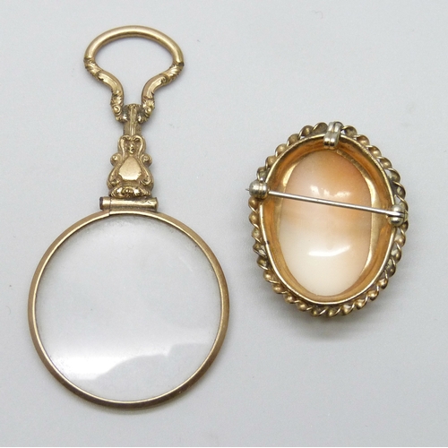 7071 - A gilt magnifying glass, 6.8cm, and a gilt cameo brooch