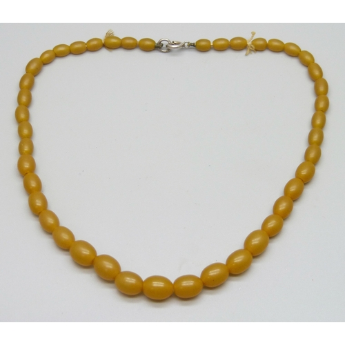 7106 - A short amber coloured bead necklace, 34.5cm