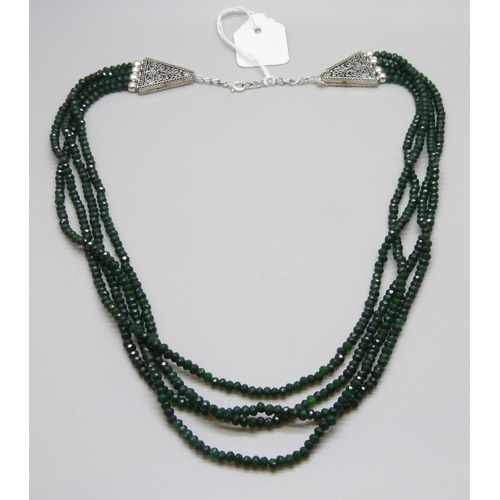 7126 - A four strand green stone bead necklace with a plated clasp (glue residue), 63g