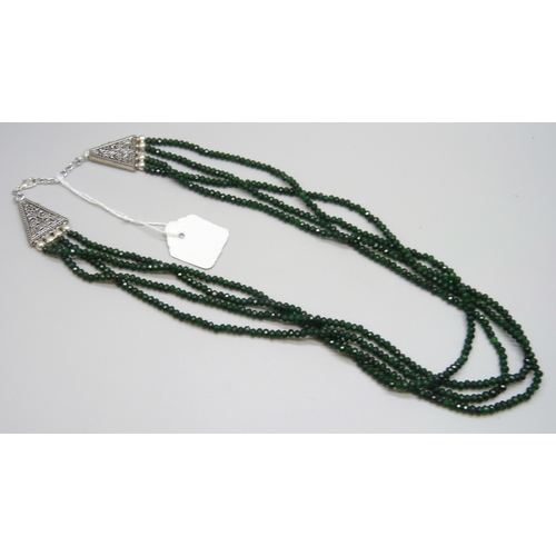 7126 - A four strand green stone bead necklace with a plated clasp (glue residue), 63g