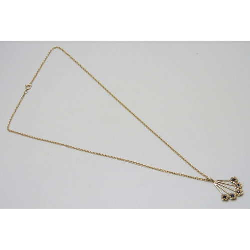 7137 - A 9ct gold and sapphire floral fan design pendant, 2.8cm including bail, on a yellow metal chain, 5.... 