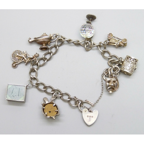 7140 - A white metal charm bracelet with a silver clasp, and a collection of silver and white metal charms,... 