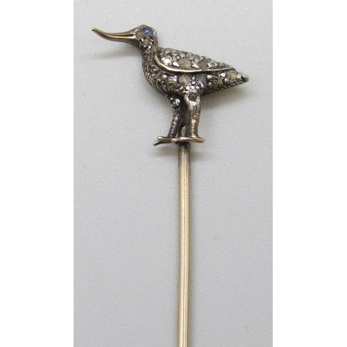7145 - A yellow metal diamond set stick pin in the form of a bird set with a sapphire eye, length altered, ... 
