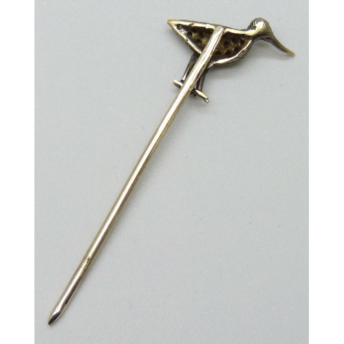 7145 - A yellow metal diamond set stick pin in the form of a bird set with a sapphire eye, length altered, ... 