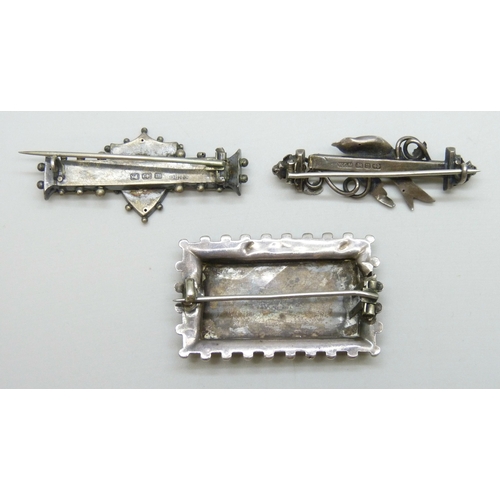 7040 - Two silver brooches, a Victorian white metal Aesthetic movement brooch, 15g total, and two gemstones