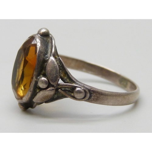 7051 - An Arts and Crafts white metal ring set with an orange stone, P