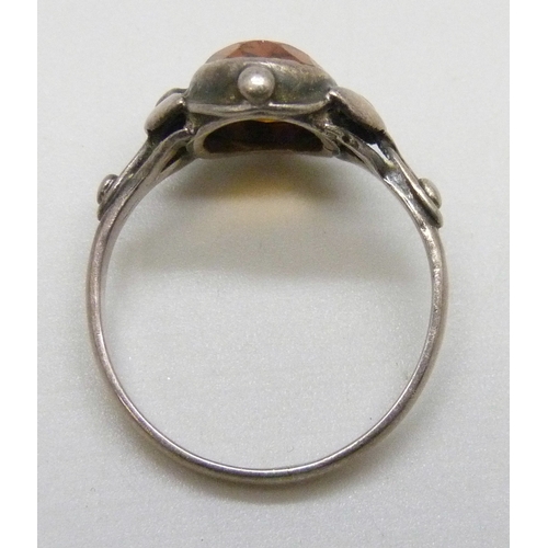 7051 - An Arts and Crafts white metal ring set with an orange stone, P