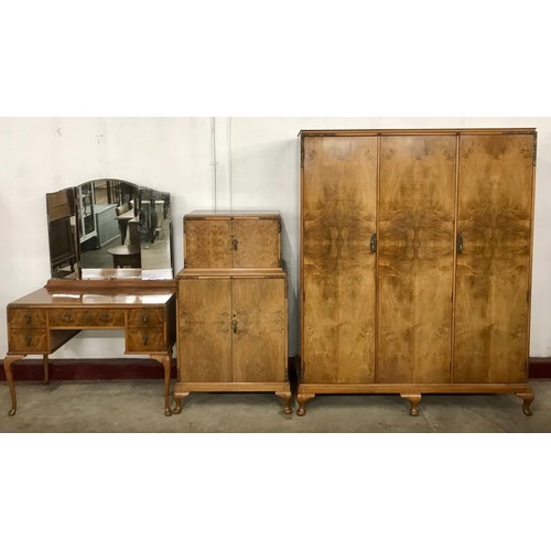 64 - An Art Deco figured walnut three piece bedroom suite, comprising; triple wardrobe, dressing table an... 