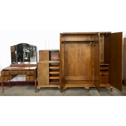 64 - An Art Deco figured walnut three piece bedroom suite, comprising; triple wardrobe, dressing table an... 
