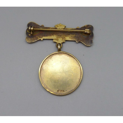 7067 - A silver gilt medallion on a silver bar, 22g, 4.5cm bar