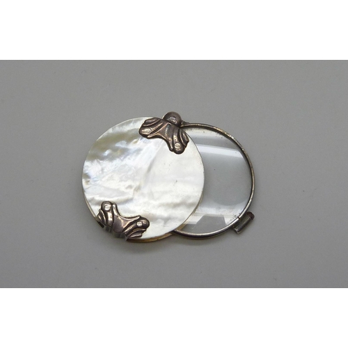 7070 - A white metal and mother of pearl eye glass, 3.9cm